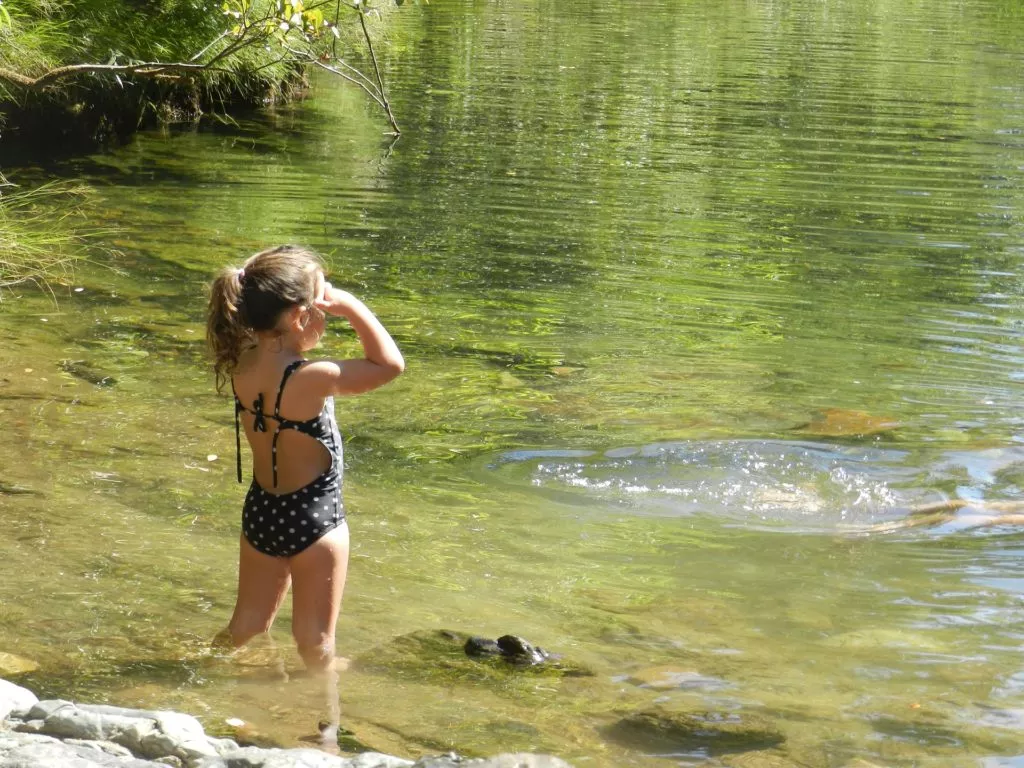 wypoczynek nad wodą- dziewczynka wchodzi do wody